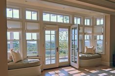 a living room filled with furniture and large windows