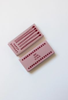 two pink business cards sitting on top of each other