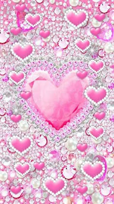 a pink heart surrounded by lots of diamonds and pearls on a pink background with sparkles