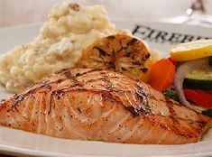 a white plate topped with salmon and veggies