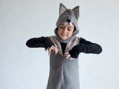 a little boy dressed in a costume with a fox on it's head and gloves