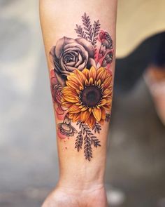 a sunflower and rose tattoo on the left leg, with other flowers around it