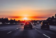 cars driving down the highway at sunset