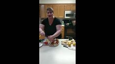 a woman is cutting fruit on a kitchen counter with other food items and utensils