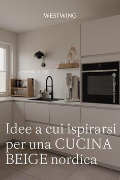 a kitchen with white cupboards and appliances in the middle of it, next to a window