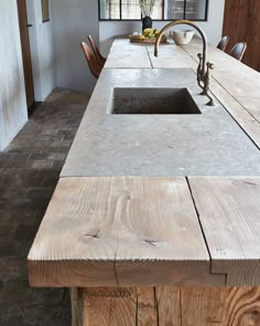 the kitchen counter is made out of wood and has a sink on one side with a faucet in the middle