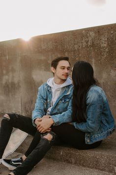 a young man and woman sitting on concrete steps