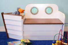 a toy bench with toys on the floor in front of it and a blue wall behind it