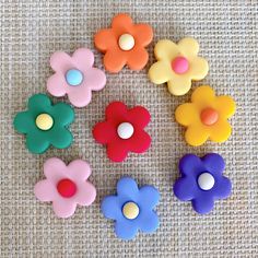 six flower shaped buttons sitting on top of a table