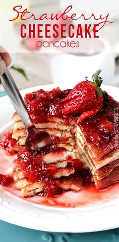 strawberry cheesecake pancake on a plate with strawberries and syrup being cut into squares