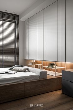 a bed sitting in a bedroom next to a window with blinds on the windowsill