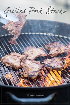 grilled pork steaks on the grill with flames and text overlay that reads grilled pork steaks