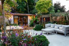 an outdoor living area with couches and flowers