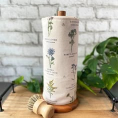 a roll of toilet paper sitting on top of a wooden table next to a brush