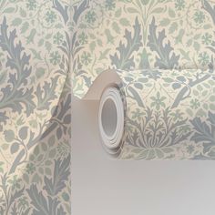 a roll of wallpaper with a floral pattern on it, next to a roll of tape