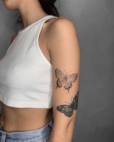 a woman with a butterfly tattoo on her left arm and right arm behind her back