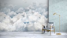 a chair sitting in front of a wall with clouds on it