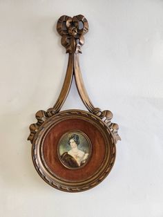 a painting hanging from the side of a wall with an ornate frame around it's edges