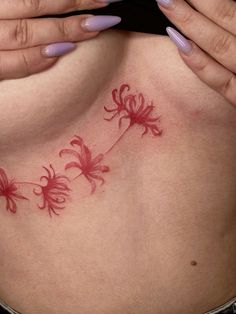 a woman's stomach with red flowers on it and her hands covering her face