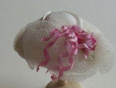 a white hat with pink ribbons on it