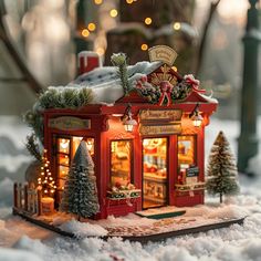 a small red store with christmas decorations and lights on the front window is in the snow