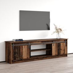 an entertainment center in the corner of a room with a large screen on the wall