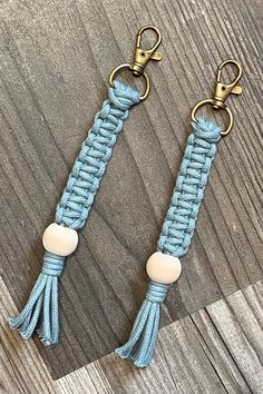 two blue and white key chains with brass hooks