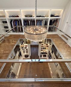 a chandelier hanging from the ceiling in a walk - in closet filled with shoes