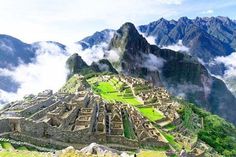 the ruins of machu picchuta are surrounded by clouds and mountains in peru