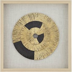 a black and white circle made out of woven material in a frame on the wall