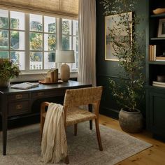 an office with green walls and wooden floors, along with a large rug on the floor