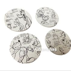 four mickey mouse coasters sitting on top of each other with various drawings in them