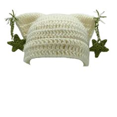 two white crocheted pillows with green bows on the sides and one is made out of