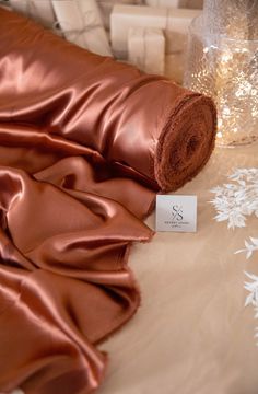 a roll of satin fabric sitting on top of a table