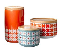 three colorful canisters with designs on them, one is orange and the other is blue