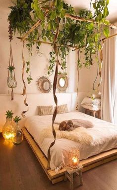 a bed with plants hanging from the ceiling