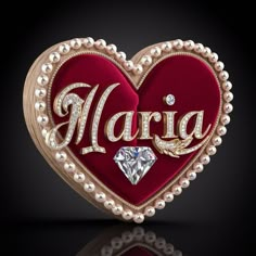 a heart - shaped brooch with the word marc written in gold and surrounded by pearls