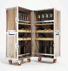 an open wooden cabinet filled with lots of bottles and glasses on wheels in front of a white background