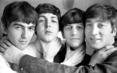 four young men are posing for a black and white photo with their arms around each other