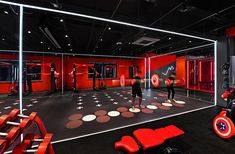 the gym is equipped with red and black equipment for people to practice their boxing moves