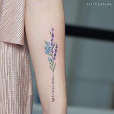 a woman's arm with a flower tattoo on the left side of her arm