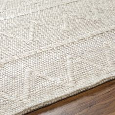 a close up view of a white rug on a wooden floor with wood floors in the background