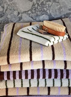 three towels stacked on top of each other with a brush and comb in the middle