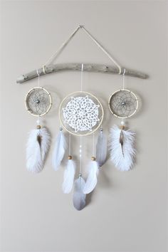 a white dream catcher hanging on a wall