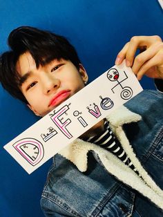 a young boy holding up a sign with the word free on it in front of his face