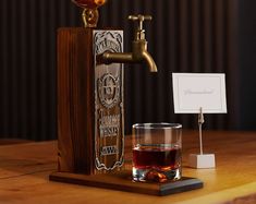 a wooden stand with a glass on it next to a faucet and business card holder