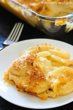 a white plate topped with macaroni and cheese next to a casserole dish