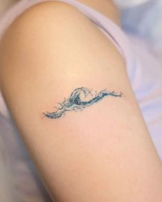 a woman's arm with a wave tattoo on it