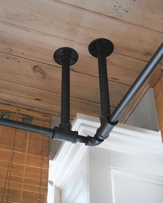 two black pipes are attached to the ceiling