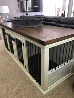 a dog kennel in the middle of a living room next to a couch and coffee table